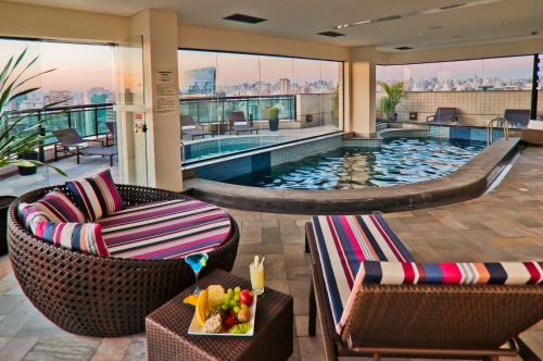 圣保罗法利亚利马蓝树高级酒店的一个带两把椅子和一张桌子的酒店游泳池