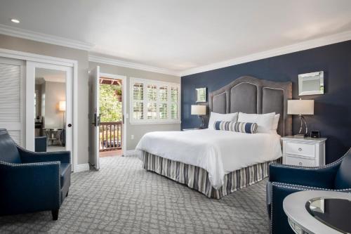卡梅尔烛光酒店的一间卧室设有一张大床和蓝色的墙壁