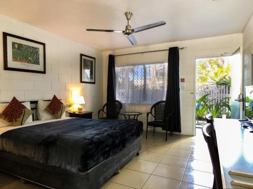 凯恩斯South Cairns Resort的一间卧室配有一张带吊扇的床