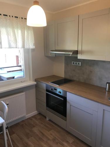 派德1-Bedroom apartment in city centre的厨房配有白色橱柜和炉灶烤箱。