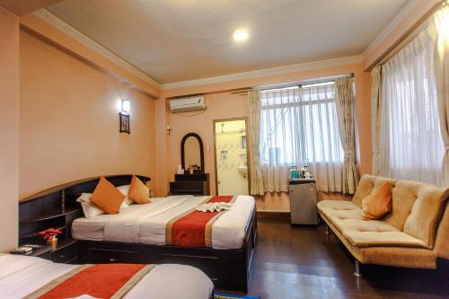 加德满都尼帕拉亚酒店的一间卧室配有两张床、一张沙发和一把椅子