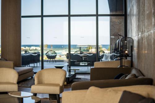 帕莫瑞Wave Resort - Ultra All Inclusive的大堂配有沙发和椅子,设有大窗户。