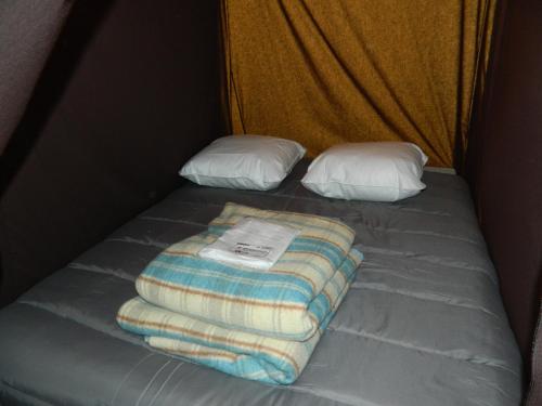 圣马迪拉莫Oh! Campings La Brise的一张带毯子的床和两个枕头