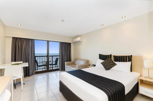 汤斯维尔水瓶座海滩酒店的酒店客房设有一张床、一张书桌和一个阳台。