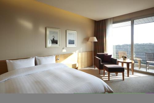 华城市蜿蜒山岭酒店的酒店的客房 - 带一张床、椅子和窗户