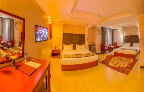 坎帕拉Russell Hotel的酒店客房配有两张床和一张书桌