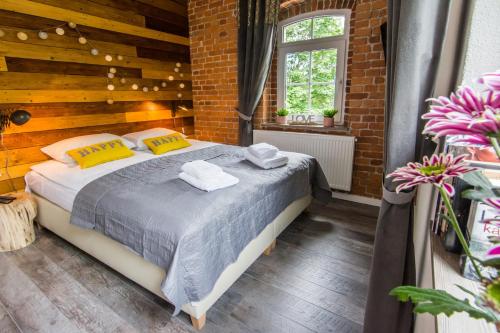 卡尔帕奇Apartamenty hoteLOVE Stara Kuźnia的一间卧室设有一张床和砖墙