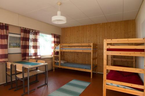 SaariharjuNikkilän Elämyskylä的客房设有两张双层床和一张桌子。