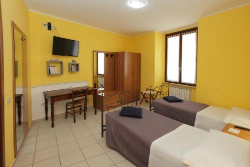 福松布罗内Il Cavallino的酒店客房配有两张床和一张书桌