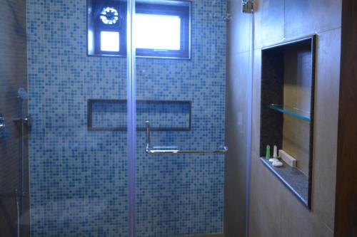 浦那Hotel Shree Panchratna Pune的浴室里设有玻璃门淋浴