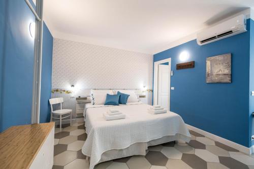 维纳利亚瑞勒Guest House - Il Cedro Reale的蓝色卧室,配有床和桌子