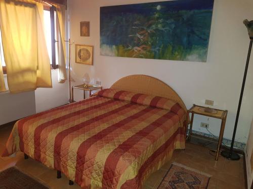 bedizzoleAL BORGO ANTICO Ristorante con camere的卧室配有一张床,墙上挂有绘画作品
