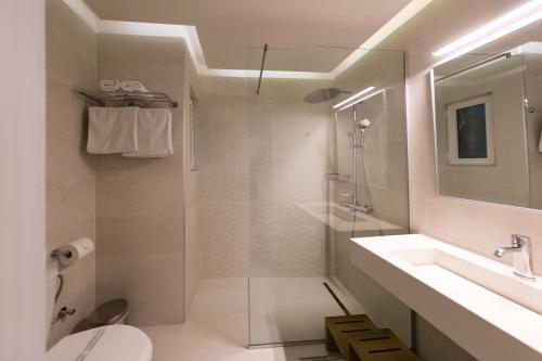 普拉坦斯Bueno Hotel的带淋浴、盥洗盆和卫生间的浴室