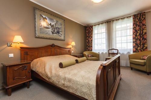 托伦萨那洛扎酒店的一间卧室配有一张大床和一把椅子