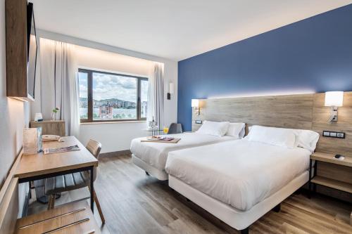 巴拉卡毕尔巴鄂门酒店的酒店客房设有一张大床和一张书桌。