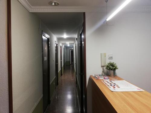 萨拉戈萨Hostal Milmarcos的走廊设有书桌和长长的走廊