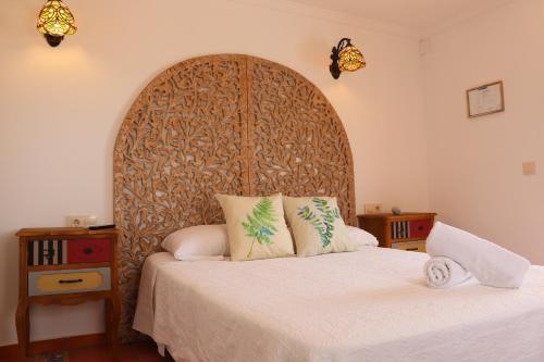 卡尔佩Hotel Casa Día y Noche的一间卧室配有一张大床和木制床头板