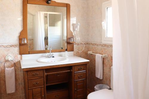 卡尔佩Hotel Casa Día y Noche的一间带水槽、镜子和卫生间的浴室
