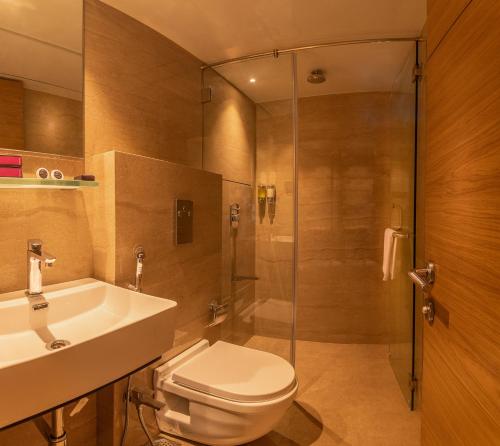孟买Hotel Metropole Inn的浴室配有卫生间、盥洗盆和淋浴。