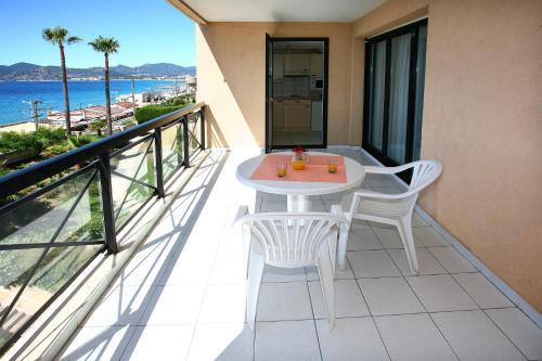 戛纳渣油维拉毛帕森酒店的一个带桌椅的海景阳台