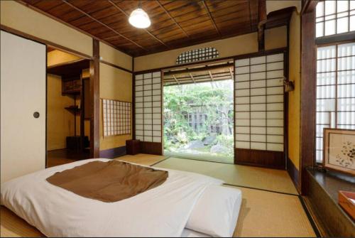 京都鲤屋宾馆的一间带床的卧室,位于带窗户的房间内