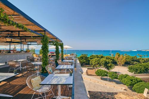 马略卡岛帕尔马Es Princep - The Leading Hotels of the World的俯瞰大海的庭院里摆放着一排桌椅