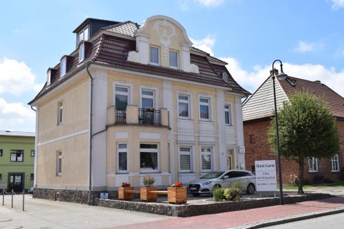 ZarrentinHotel Garni Villa am Schaalsee的前面有一辆汽车停放的白色房子