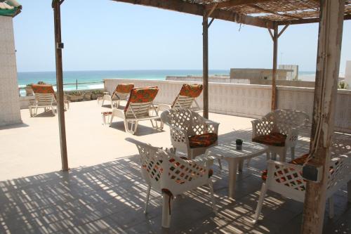 达喀尔Auberge Keur Diame的海滩甲板上的一组桌椅