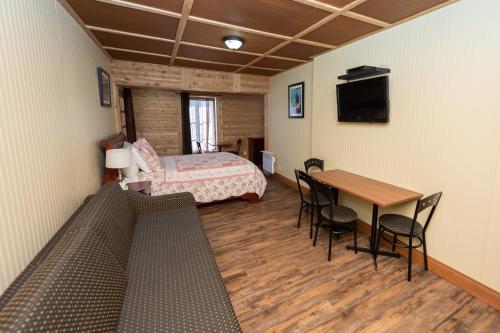 圣弗朗索瓦小河乐佛阿庞小旅馆的配有一张床和一张桌子及椅子的房间