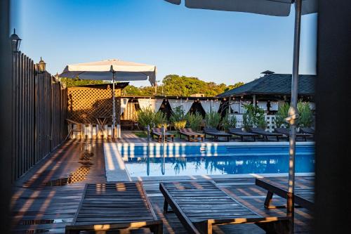 苏科Rezidenzia Utrish Hotel的一个带长椅和遮阳伞的游泳池