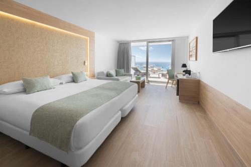 帕尔马诺瓦Elba Sunset Mallorca Thalasso Spa的一间带大床的卧室和一间客厅