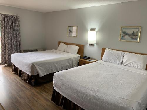 韦恩斯维尔Days Inn by Wyndham Waynesville NC的酒店客房设有两张床和窗户。