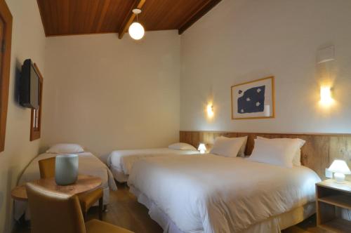 特雷索波利斯Hotel Magique Le Canton的酒店客房设有两张床和一张桌子。