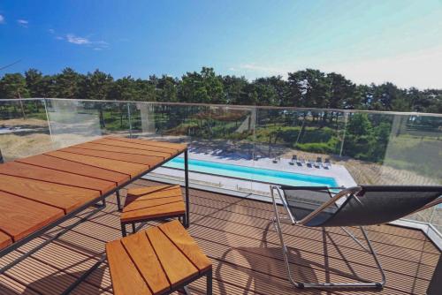宾茨Inselloft-Rügen的一个带桌椅的阳台和一个游泳池