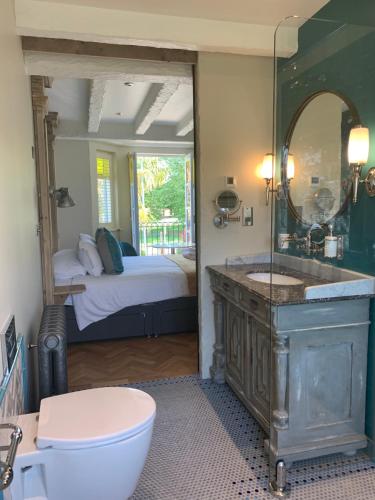 圣奥斯特尔布拉德雷旅舍的一间带水槽和镜子的浴室以及一张床