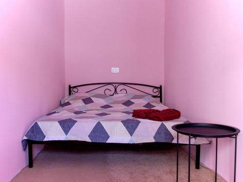 敖德萨квартира в центре的一间卧室配有一张紫色墙壁的床和两张桌子