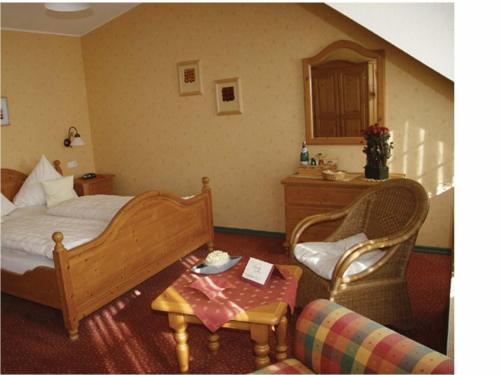 罗斯巴赫祖尔邮政酒店-餐厅的卧室配有1张床、1张桌子和1把椅子
