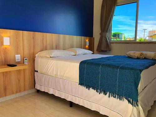 阿奎拉兹Pousada Brisa do Mar的一间卧室设有一张蓝色墙壁的大床