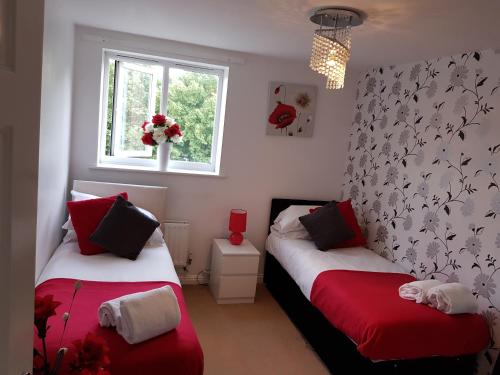 巴塞尔顿Vetrelax Basildon Crosse Apartment的红色和白色的客房内的两张床