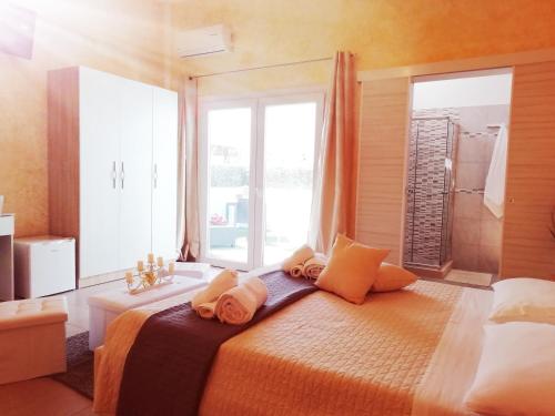 拉卡莱b&b MareSalento的卧室配有带枕头的床铺和窗户。