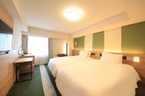 福冈Richmond Hotel Tenjin Nishi-Dori的酒店客房设有两张床和窗户。