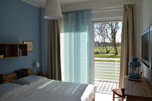奥茨塞巴德·迪尔哈根LeinenLos im Kajüting的一间卧室设有一张床和一个滑动玻璃门