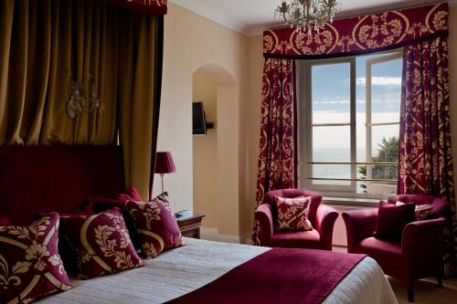 文特诺皇家酒店的一间卧室设有大窗户、一张床和椅子