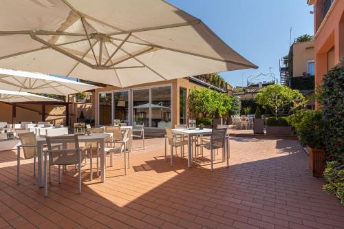罗马特雷维哈利的酒吧酒店及餐厅的一个带桌椅和遮阳伞的户外庭院。