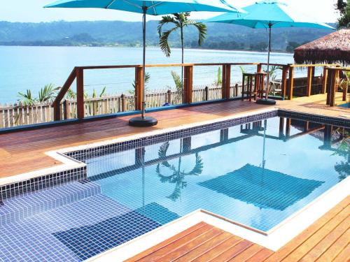 维拉港瓦努阿图海滨公寓酒店的水边带遮阳伞的游泳池