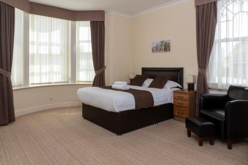 雷特福德草坪旅馆的一间卧室配有一张床、一把椅子和窗户。