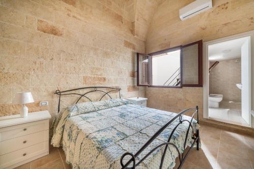 圣潘克拉齐奥萨伦蒂诺Casetta Annarosa by BarbarHouse的一间卧室配有一张床,浴室设有窗户