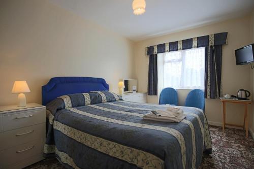 伯恩茅斯拉古娜酒店的一间卧室设有蓝色的床和窗户。