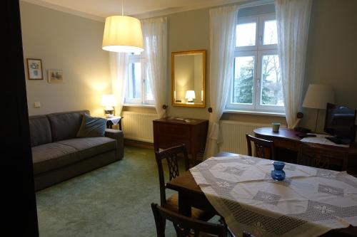 ReitweinPension Gräfliche Villa的一间带桌子和沙发的客厅以及一间用餐室