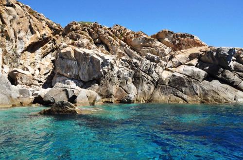 Isola del GiglioAccogliente monolocale的岩石山旁的水域